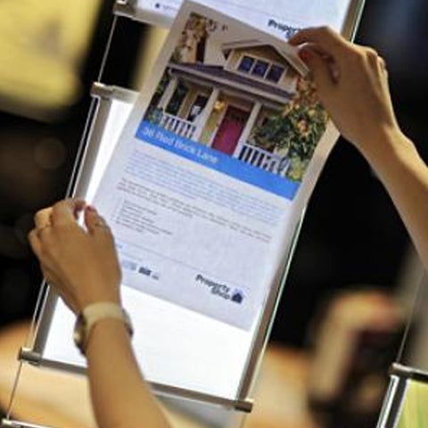 person inserting flyer printed on mid west displays premium backlit paper